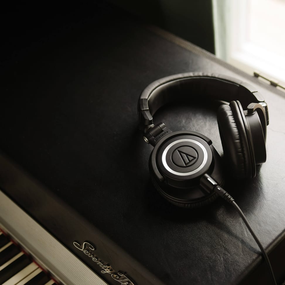 ATH-M50X posé sur un piano, coussinets en cuir et coque fermée