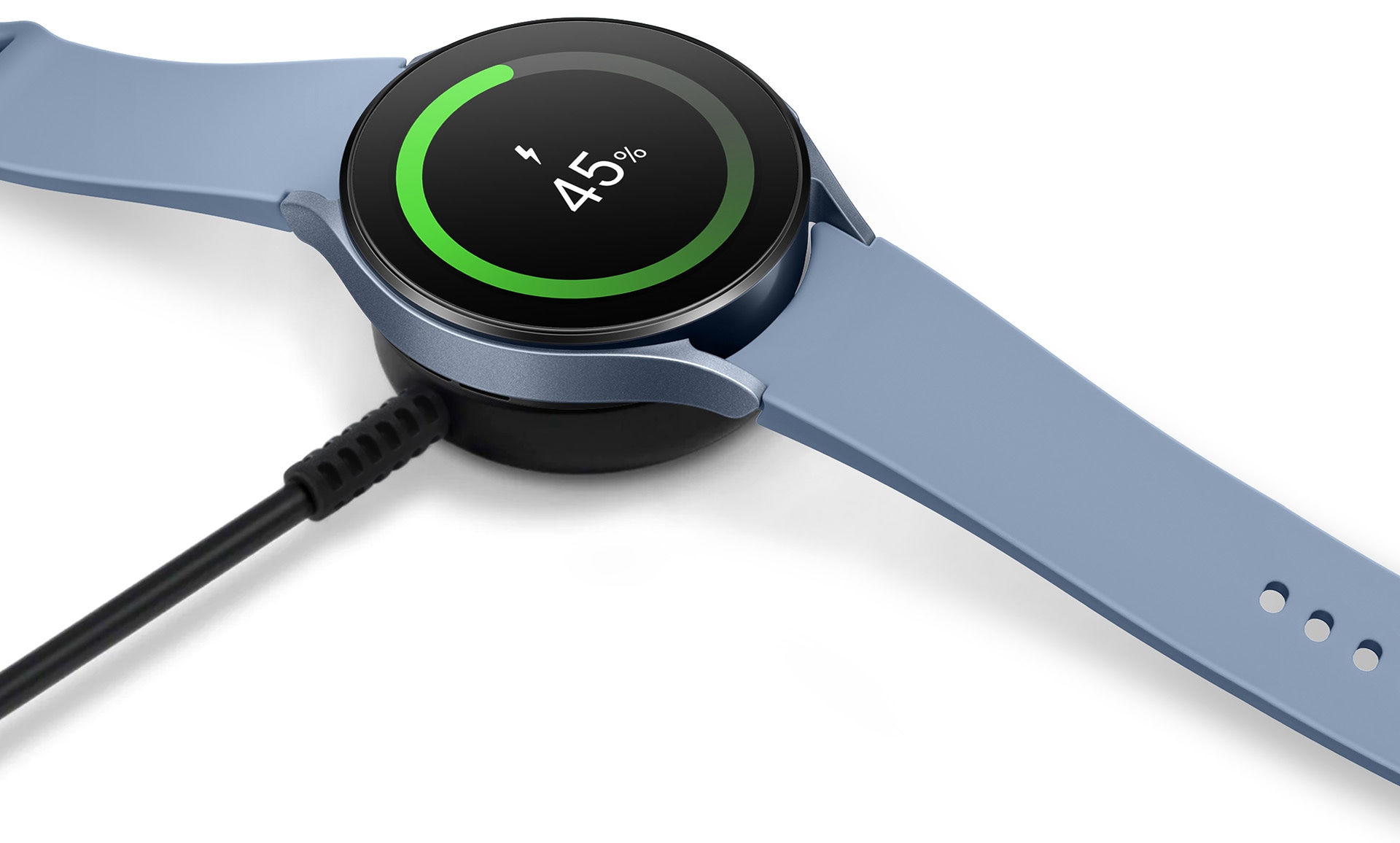 Une Sapphire Galaxy Watch5 au-dessus d'un chargeur sans fil en noir montrant une charge de 45% sur le visage.