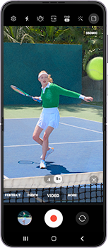 L&rsquo;application Appareil photo est ouverte et en mode d&rsquo;enregistrement vid&eacute;o. Une femme joue au tennis dans le viseur.