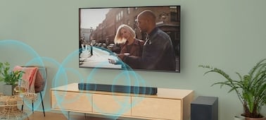 Ondes sonores bleues émises par une barre de son posée sur un meuble en dessous d'un téléviseur fixé au mur
