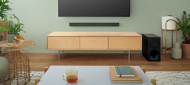 Point de vue de l'utilisateur d'un téléviseur fixé au mur et d'une barre de son dans un salon