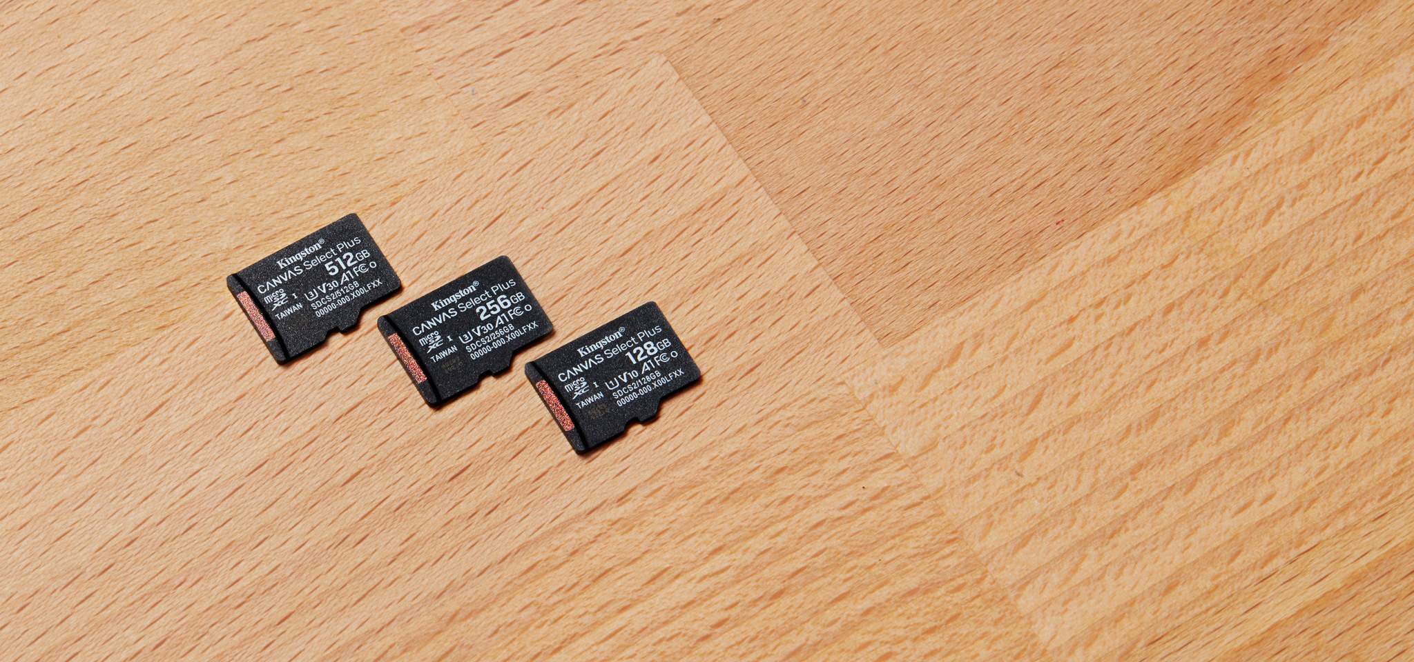 Trois cartes microSD Canvas Select Plus, chacune d&rsquo;une capacit&eacute; diff&eacute;rente, pos&eacute;es sur un bureau en bois