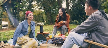 Image de personnes assises autour de l'enceinte portable sans fil SRS-XE200 Série X