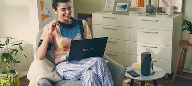Image d'une personne avec son ordinateur portable et l'enceinte portable sans fil SRS-XE200 Série X