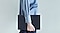 Une personne portant une chemise bleue marche en tenant une Galaxy Tab S9 &eacute;quip&eacute;e d&rsquo;un Book Cover Keyboard fin.