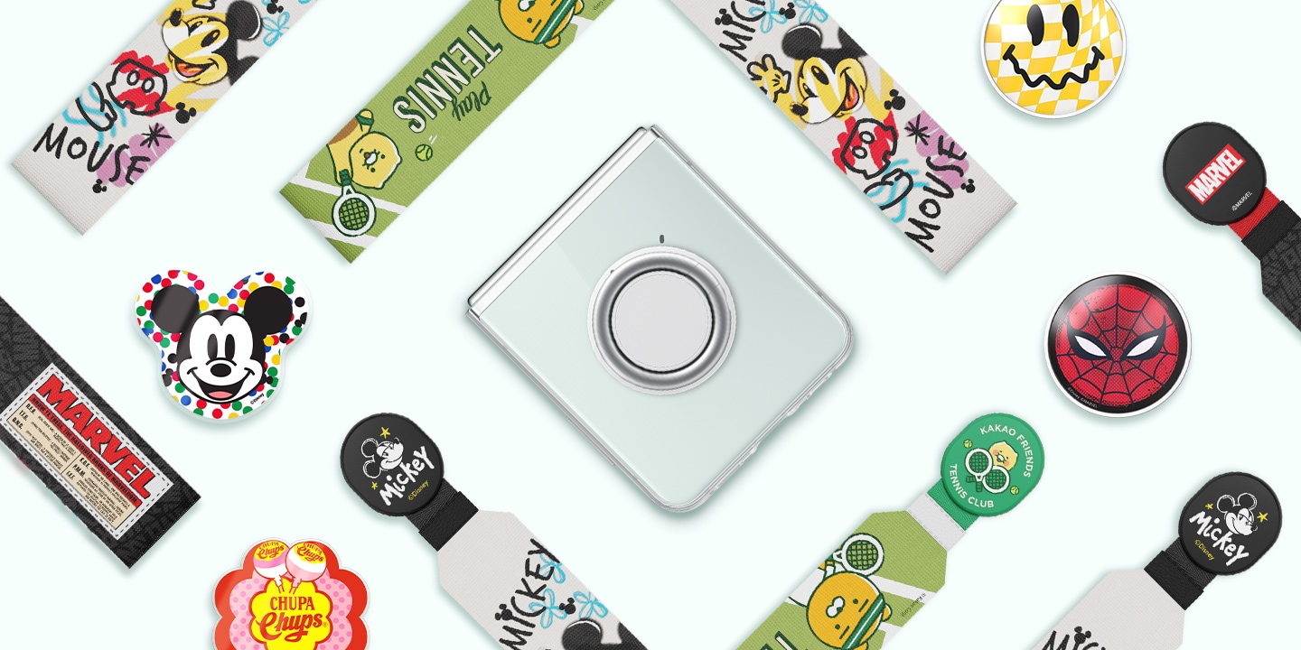 Une vue &agrave; plat d'accessoires color&eacute;s issus de collaborations, y compris des lani&egrave;res et des poign&eacute;es align&eacute;s les uns &agrave; c&ocirc;t&eacute; des autres est montr&eacute;e. Ils entourent un smartphone Galaxy Z Flip5 pli&eacute;, muni d'une coque transparente avec support amovible, plac&eacute;e au centre.