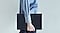 Une personne portant une chemise bleue marche en tenant une Galaxy Tab S9 Ultra &eacute;quip&eacute;e d&rsquo;un Book Cover Keyboard fin.