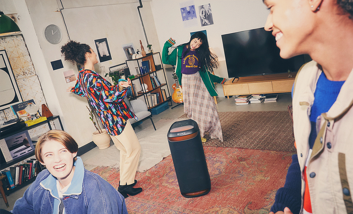 Image de quatre personnes dans un salon qui dansent autour de l'enceinte SRS-XV800 avec un &eacute;clairage d'ambiance rouge