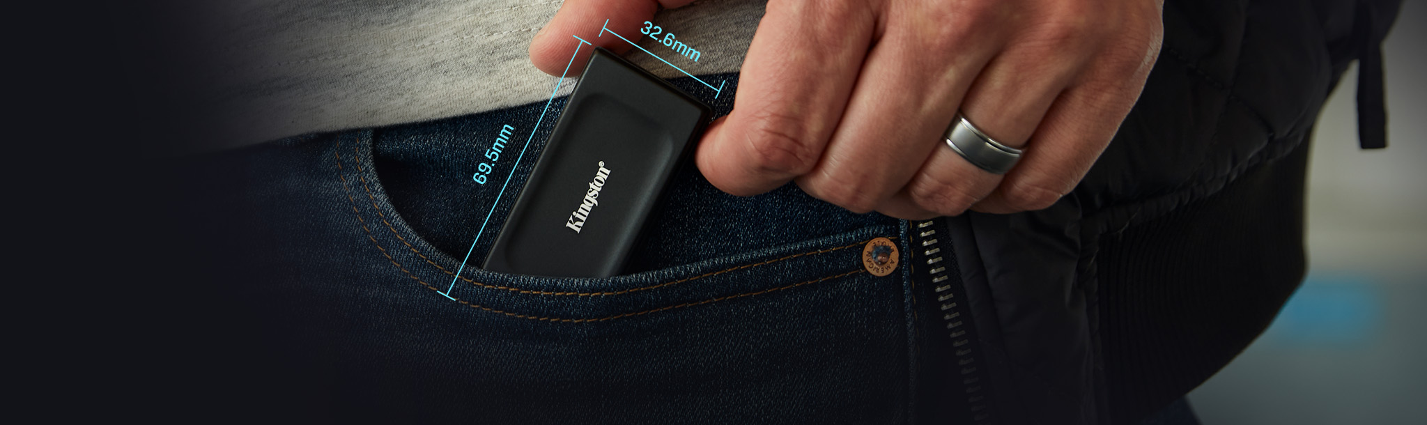 Une main tenant le SSD portable XS1000 avec les dimensions indiqu&eacute;es : 69,54 x 32,58 x 13,5 mm