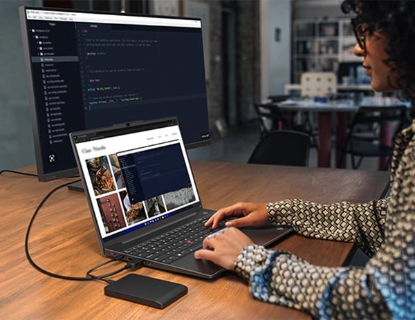 Personne à une table regardant des images sur un portable Lenovo ThinkPad E16 (16