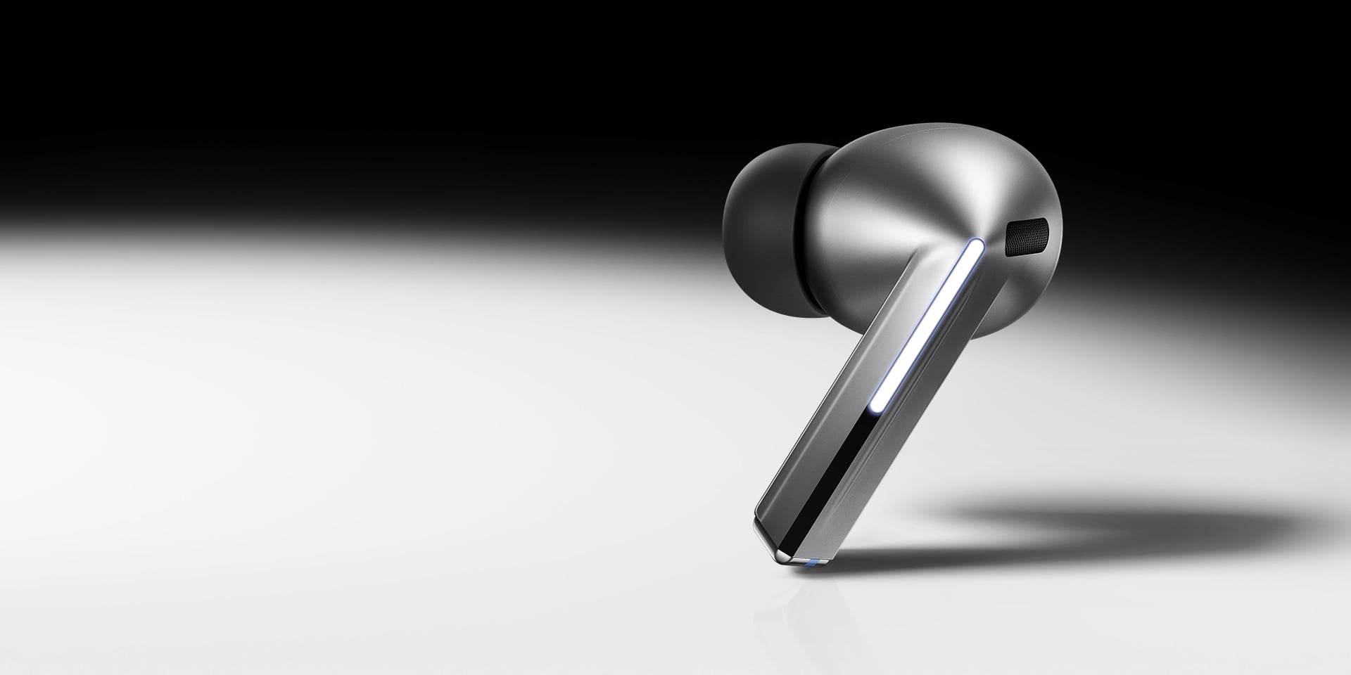 Un &eacute;couteur Galaxy Buds3 Pro Argent sur un fond d&eacute;grad&eacute; noir et blanc.