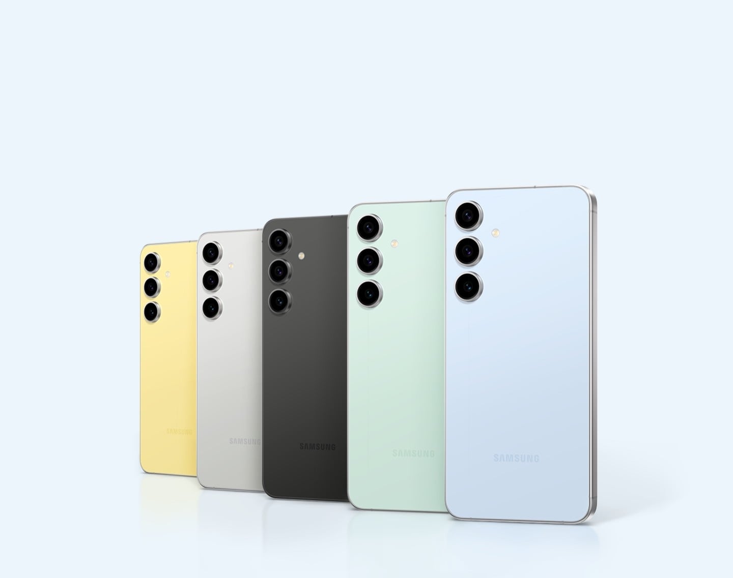 Cinq Galaxy S24 FE Jaune, Gris, Graphite, Menthe et Bleu pos&eacute;s debout. Les appareils sont vus de l&rsquo;arri&egrave;re, partiellement superpos&eacute;s.