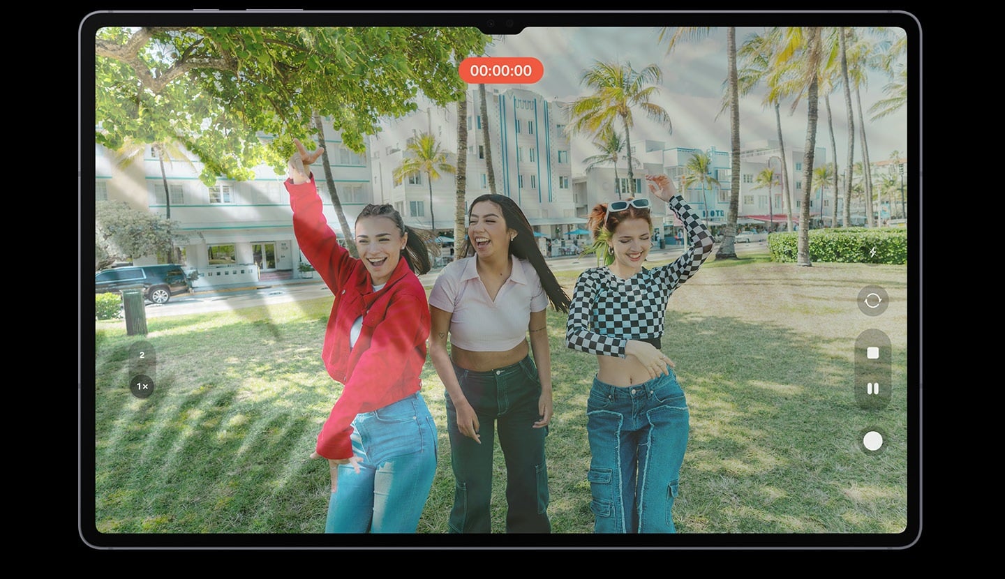 L&rsquo;&eacute;cran de la tablette affiche un enregistrement vid&eacute;o de trois femmes posant avec joie. Des reflets et &eacute;blouissements apparaissent &agrave; l&rsquo;&eacute;cran, ce qui rend l&rsquo;image affich&eacute;e floue.