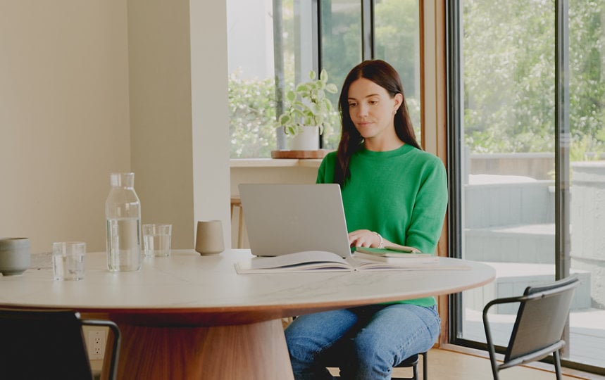 Une femme travaille tranquillement sur son ordinateur portable.