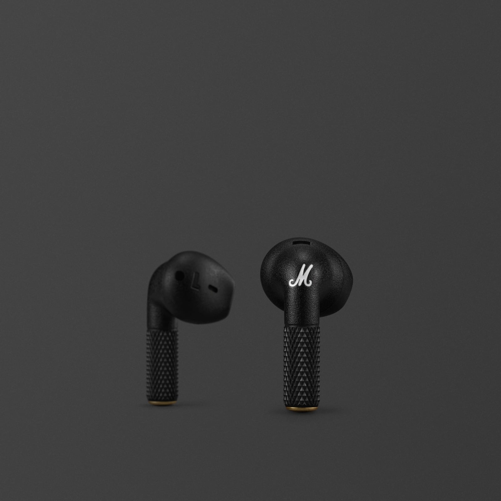 Une paire d'écouteurs noirs Marshall Minor IV Black sur un fond sombre.