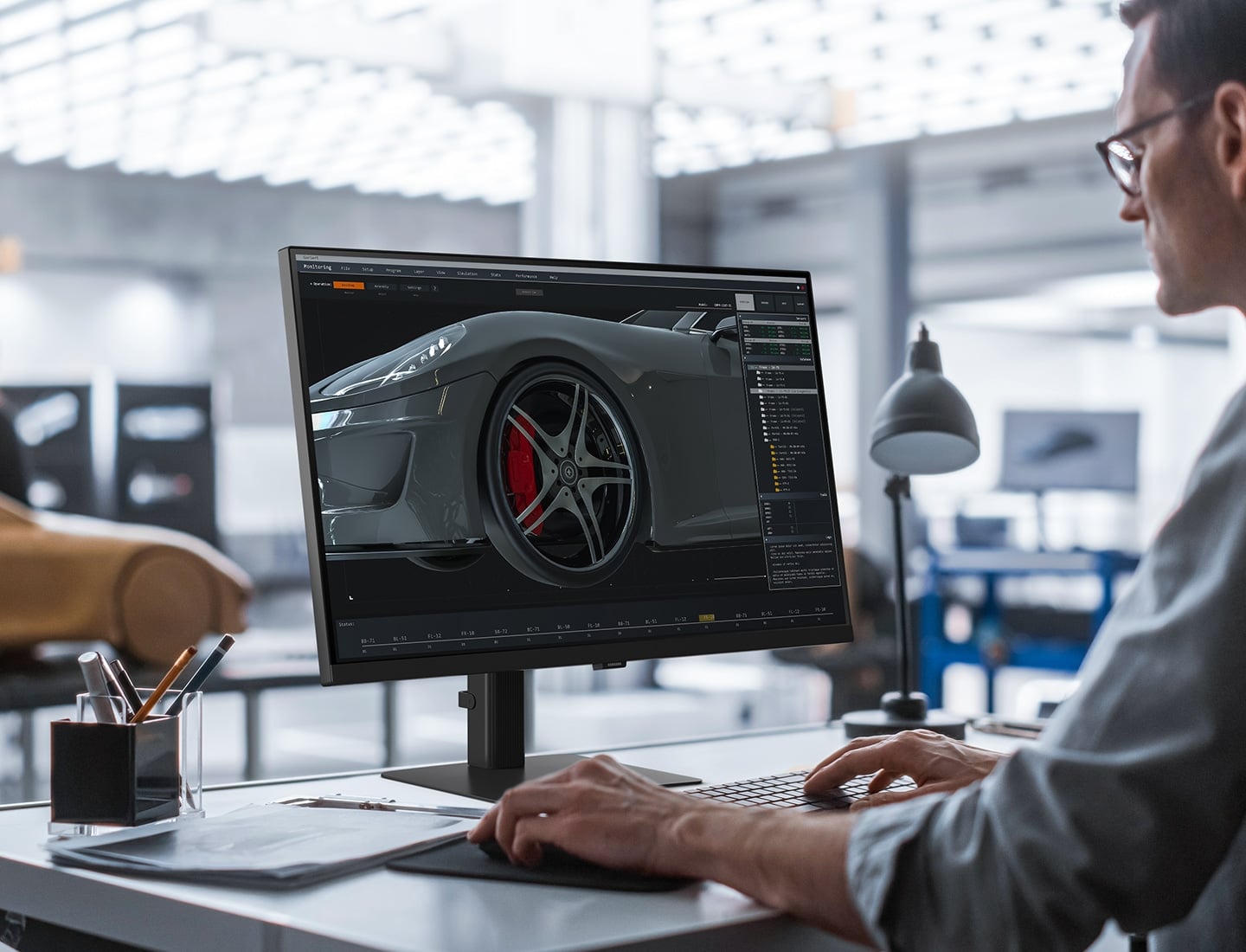 Un homme est assis &agrave; son bureau et on voit un prototype de voiture derriere son &eacute;cran. Il est en train de modifier l&rsquo;image d&rsquo;une voiture sur son &eacute;cran. Au-dessus du moniteur, on peut lire&nbsp;: &laquo;&nbsp;D&eacute;veloppez votre univers cr&eacute;atif.&nbsp;&raquo;