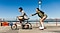 A split-screen with a line in the middle shows a man and a woman near the beach. On the left, which appears slightly blurry, the man is riding a bike. On the right side, which is sharp and clear, the woman is holding onto the man's bike wearing roller skates, highlighting the OIS feature of Galaxy A26 5G.
