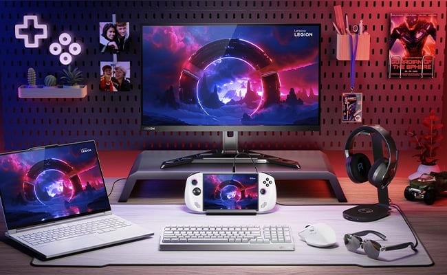 Gaming setup featuring Lenovo Legion Go S Gen 1 (8") handheld connected to a monitor, laptop, and accessories.