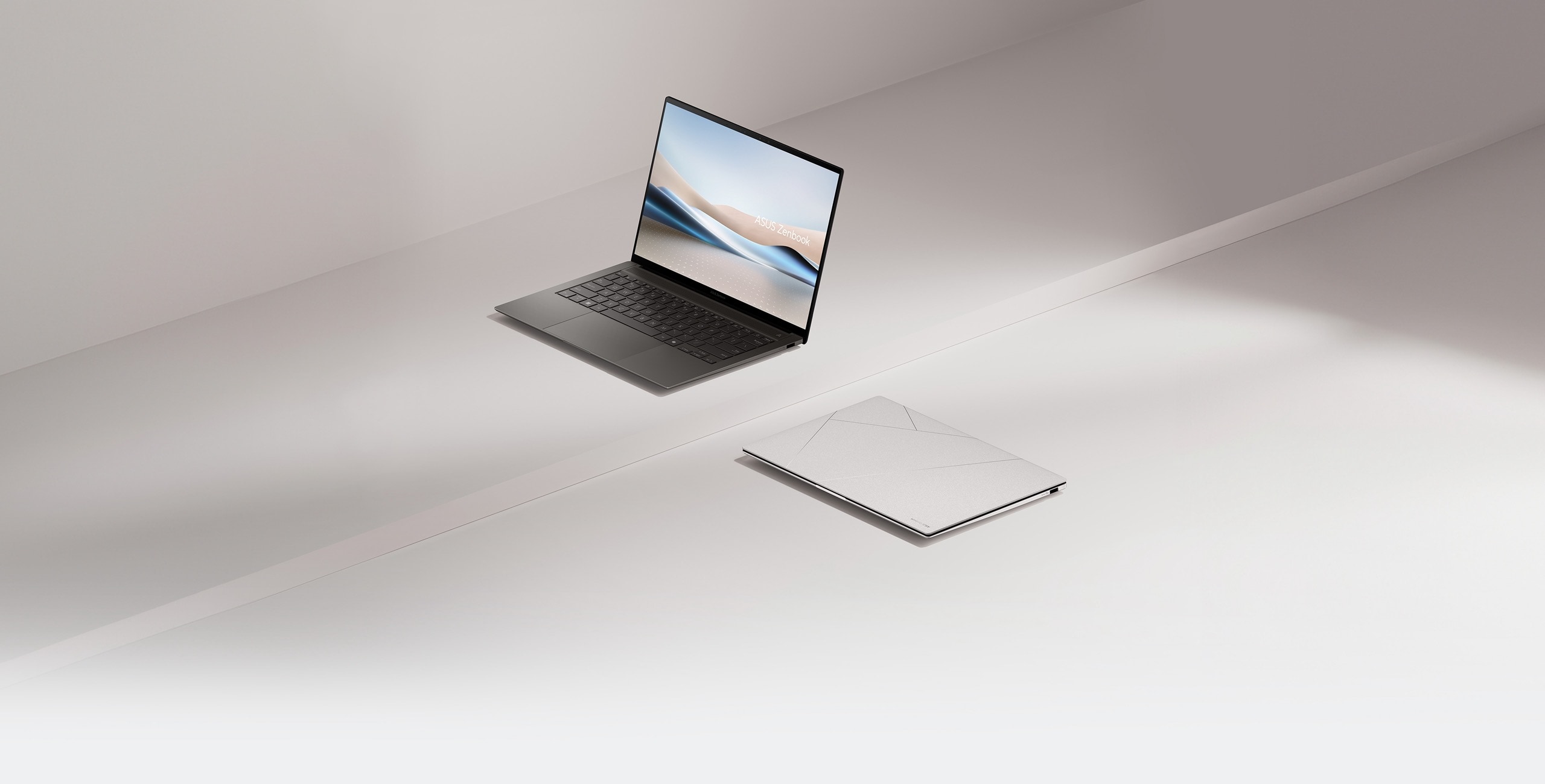 Deux Zenbook S 14, l'un ouvert &agrave; 100 degr&eacute;s et vu de l'avant gauche, l'autre ferm&eacute; et pos&eacute; au sol.