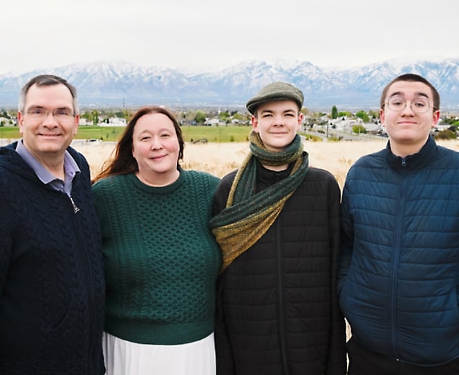 Groupe de personnes posant pour une photo avec des montagnes en arri&egrave;re-plan