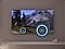 A TV depicts a scene of a train passing by a scenic outdoor location. As it does, sound waves appear near where the train touches the tracks, indicating the noise within the scene.