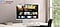 Monitor on desk displays Smart TV Apps page with various content and apps lined up. Samsung TV Plus logo.