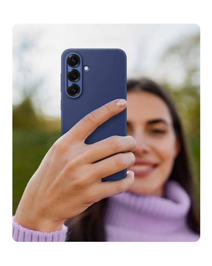 Une personne tient un Galaxy S25 &eacute;quip&eacute; de la Silicone Case en Bleu.