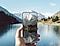 Une personne tient un Galaxy S25 avec le Anti-reflecting film install&eacute; sur son &eacute;cran. Avec un lac scintillant en arri&egrave;re-plan, l'&eacute;cran du t&eacute;l&eacute;phone reste parfaitement visible.