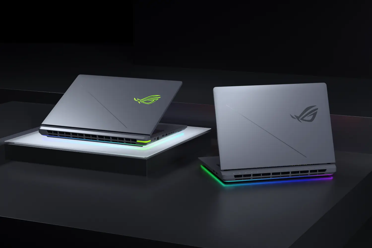Deux ordinateurs portables ROG Strix sur une table avec les couvercles partiellement ouverts.