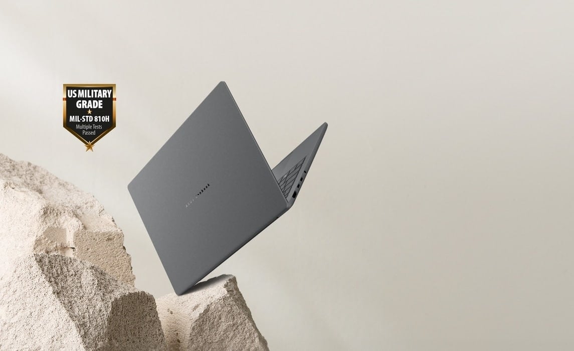 Un Zenbook A14 gris tombe sur un rocher et s'ouvre &agrave; 80 degr&eacute;s vers l'arri&egrave;re droit.