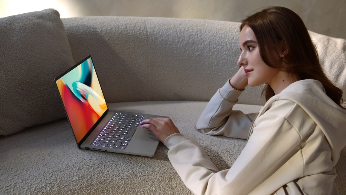 Une image montre une femme regardant une vid&eacute;o color&eacute;e sur un Zenbook A14 gris.