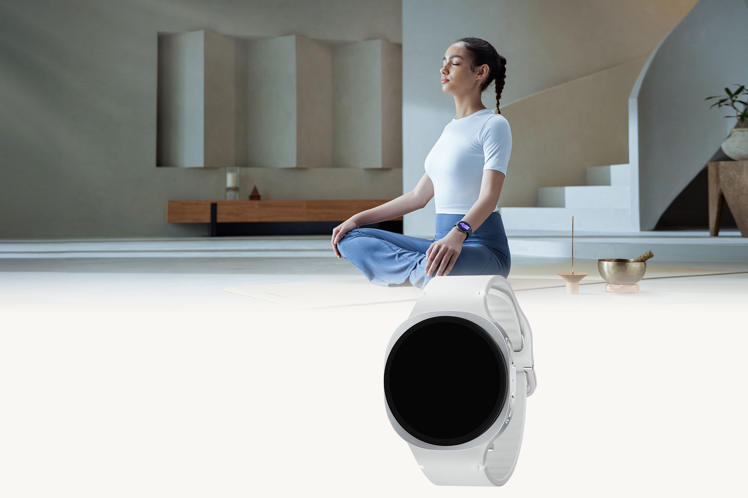 Une femme assise en tailleur &agrave; l&rsquo;int&eacute;rieur, les yeux ferm&eacute;s, portant la Galaxy Watch8 &agrave; son poignet.