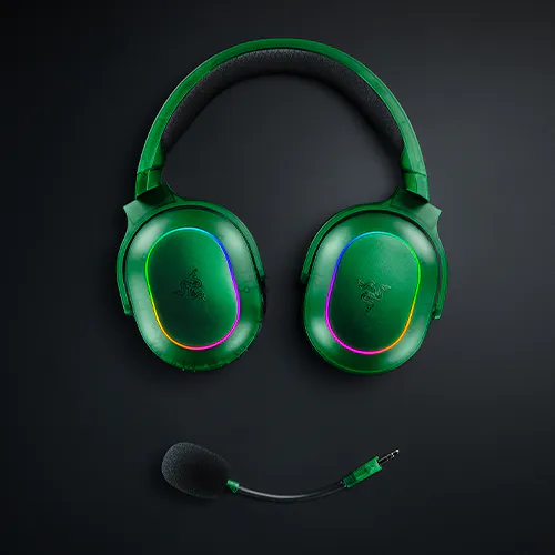Vert Razer gaming headset with &Eacute;CLAIRAGE RGB and adjustable mic, placed on a dark surface. No visible text on the headset.