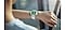 Une personne portant une Galaxy Watch8 Classic avec un bracelet Hybride pour Galaxy Watch8 Blanc regarde le cadran de sa montre.