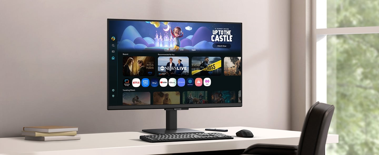 Un moniteur plac&eacute; sur un bureau affiche la page d&rsquo;applications Smart TV avec divers contenus et applications dispos&eacute;s de mani&egrave;re ordonn&eacute;e.