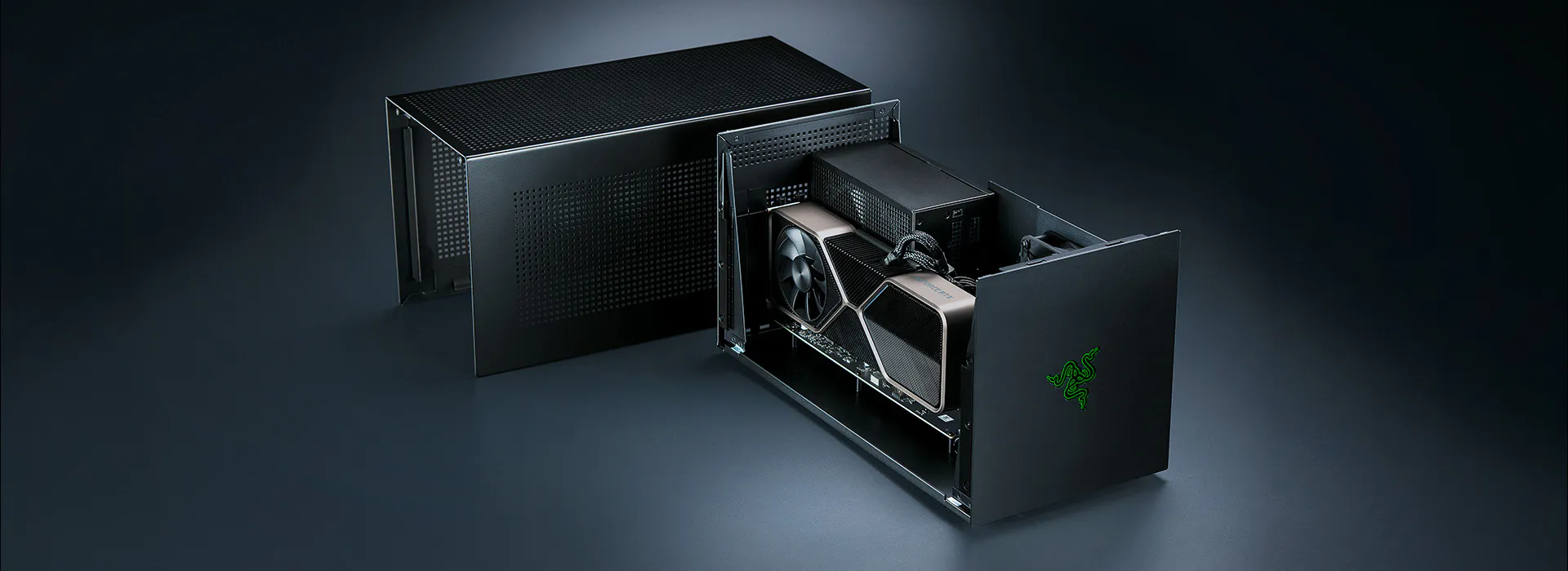 High-end black gaming PC with a Razer green logo, partially disassembled, revealing the graphics card inside a sleek, modern case.