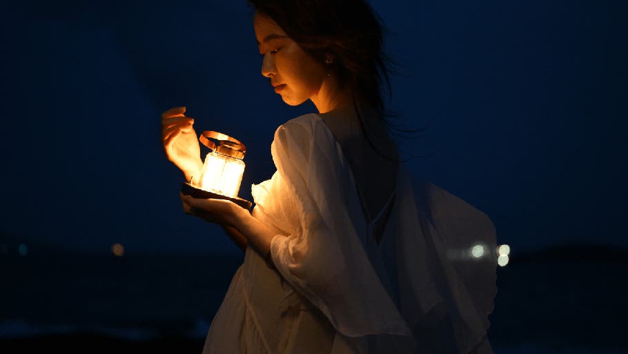 Femme regardant une lampe allumée la nuit&nbsp;-&nbsp; Photographiée avec le NIKKOR&nbsp;Z 24-70&nbsp;mm f/2.8 S&nbsp;II | Appareils photo, objectifs et accessoires Nikon