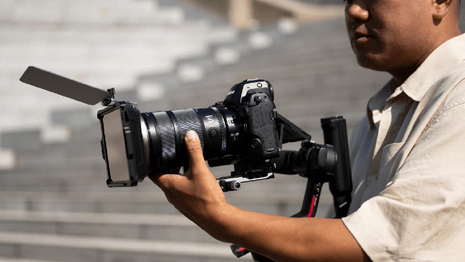 Homme tenant l’objectif NIKKOR&nbsp;Z 24-70&nbsp;mm f/2.8 S&nbsp;II pendant un tournage sur plateau | Appareils photo, objectifs et accessoires Nikon