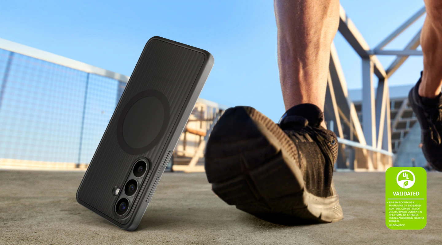 Un Galaxy&nbsp;S26 dans une coque magnétique robuste noire est en train de tomber à un pas d’une personne, pour mettre en évidence la durabilité de la coque et sa résistance pour une utilisation en extérieur. Une marque de validation de la déclaration environnementale UL est présentée «&nbsp;VALIDÉ PAR UL. L’EF-RS942 CONTIENT AU MOINS 7&nbsp;% DE MATÉRIAUX BIOSOURCÉS, DONT 24&nbsp;% DE MATÉRIAUX BIOSOURCÉS DANS LE CADRE DE L’EF-RS942, TESTÉ SELON LA NORME ASTM D6866-24. UL.COM/ECV&nbsp;».