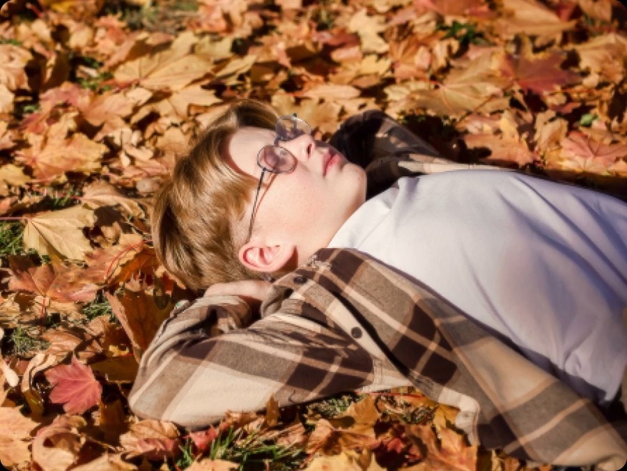 Image d’un petit garçon allongé au sol, couvert de feuilles d’automne. Plusieurs points sont détectés — le visage du garçon, ses cheveux, ses vêtements et les feuilles — puis mis à l’échelle en&nbsp;4K, tout comme le reste de l’image. Le résultat est une image beaucoup plus nette où des détails subtils sont visibles.