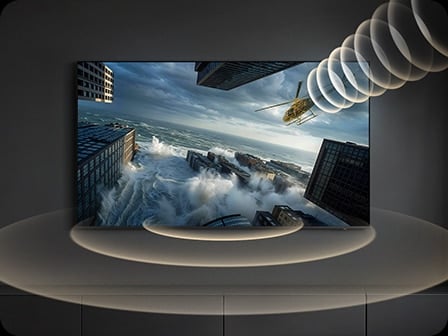 Un téléviseur Samsung affiche un hélicoptère traversant l’écran, tandis que des ondes sonores visuelles suivent son mouvement, illustrant la fonction Object Tracking Sound qui oriente le son pour correspondre au mouvement à l’écran.