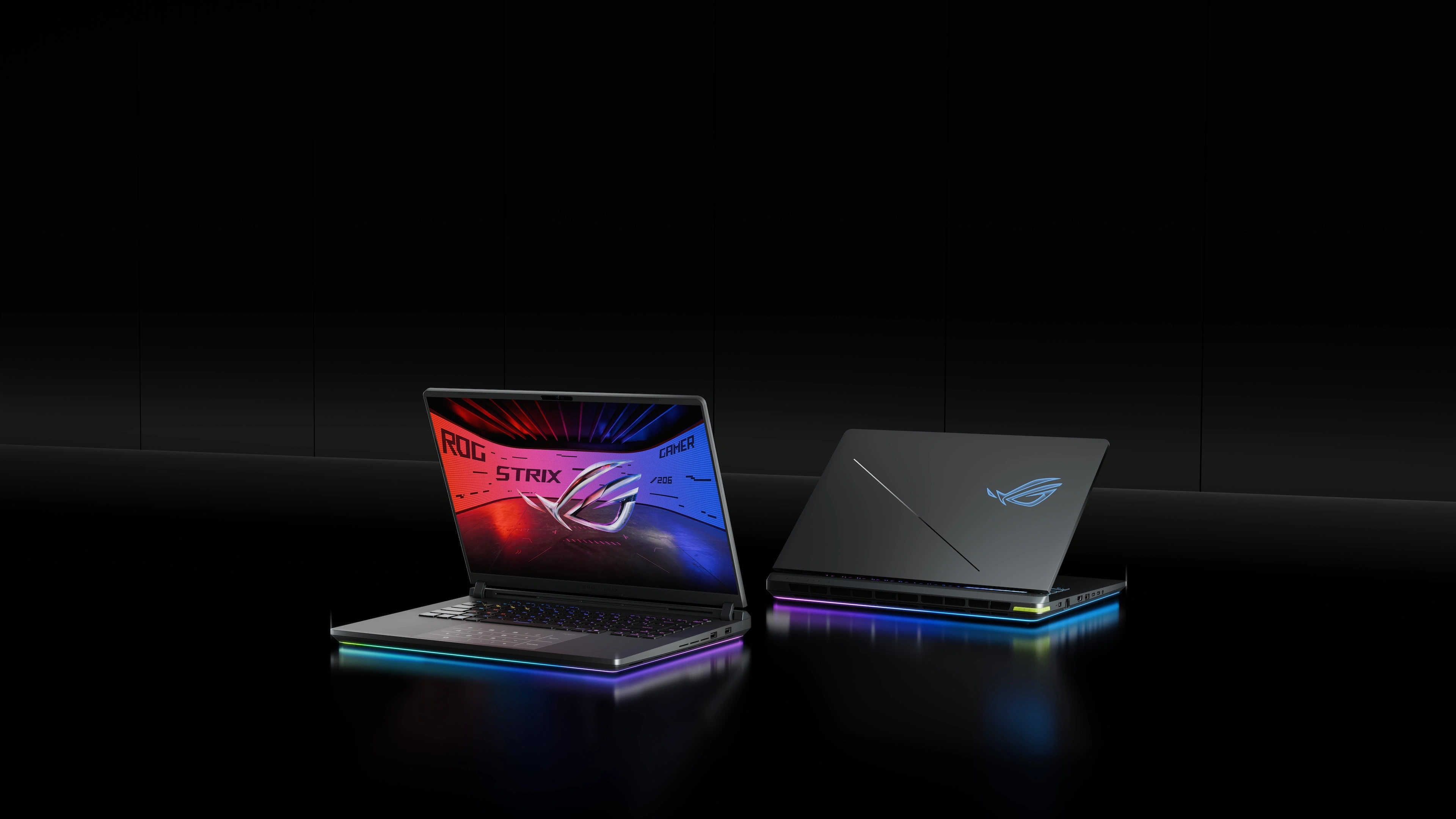 Deux ordinateurs portables ROG Strix sur une table avec les couvercles partiellement ouverts.