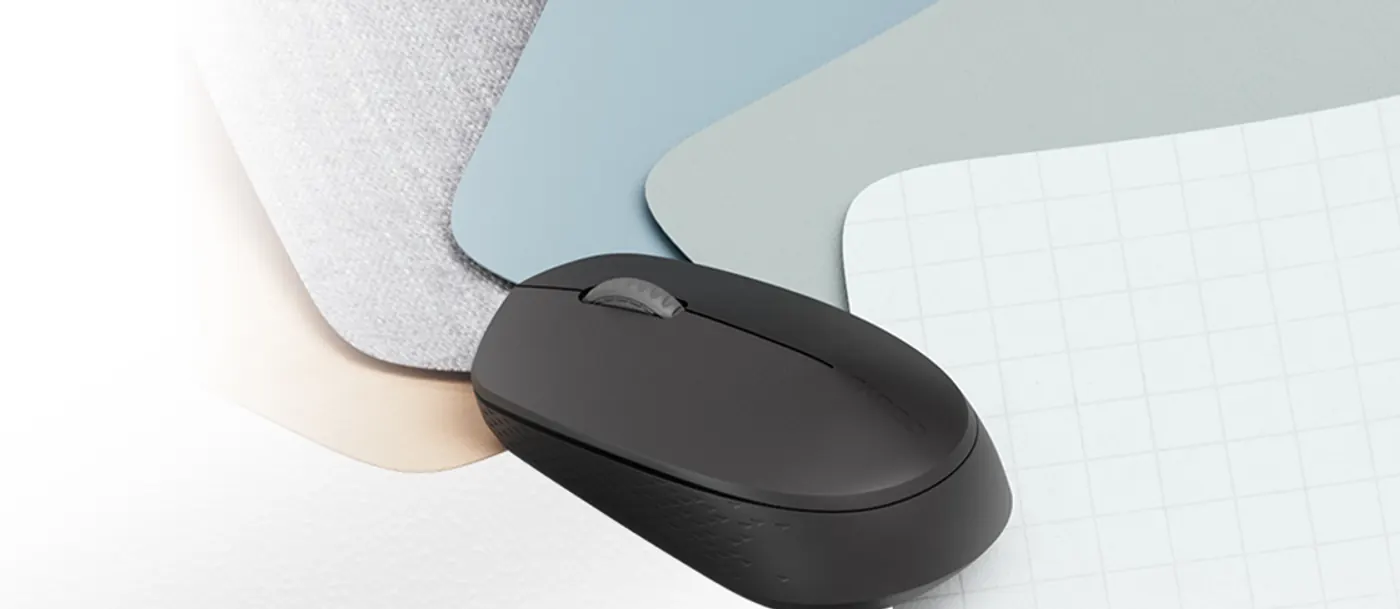 Souris Rapoo M100 Silent gris foncé posée sur des sous-mains colorés