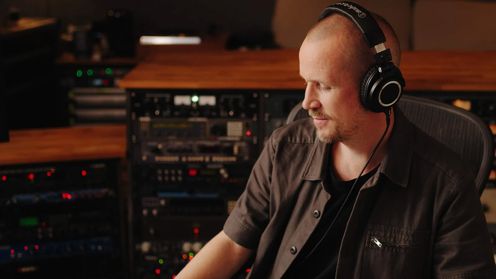 Ingénieur du son portant l'ATH-M50X devant une console de mixage en studio
