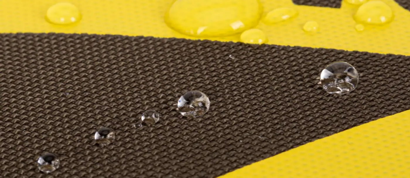Gouttes d'eau perlant sur la toile kaki et le ruban jaune du sac Rivacase 5431