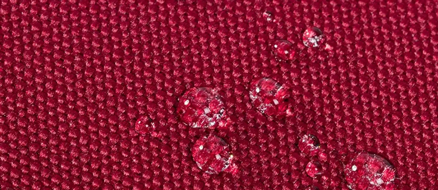 Gouttes d'eau perlant sur la toile rouge déperlante du sac Rivacase 5432