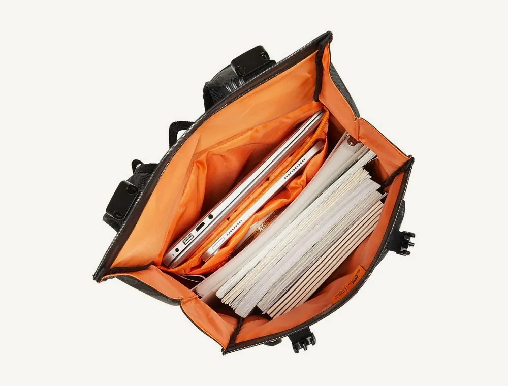 Sac à dos roll-top Rivacase 7621 ouvert vu du dessus, doublure orange, ordinateur et documents rangés