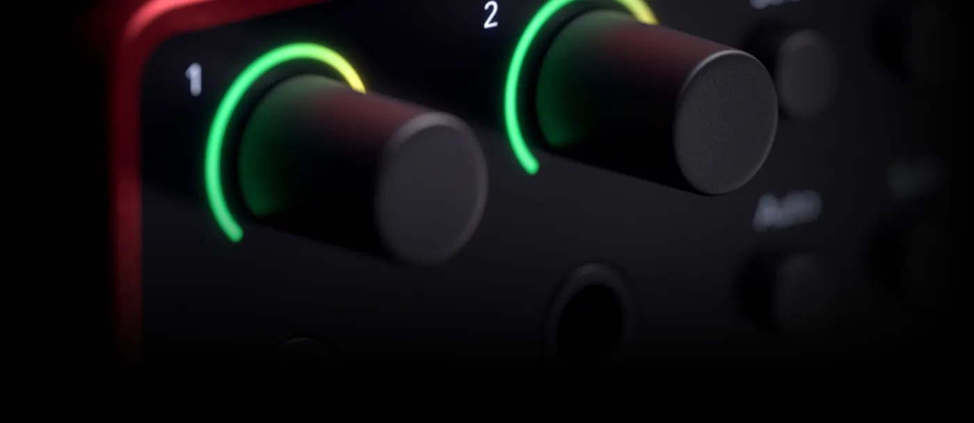 Gros plan sur les deux boutons de gain du Scarlett 2i2 et leur halo lumineux vert