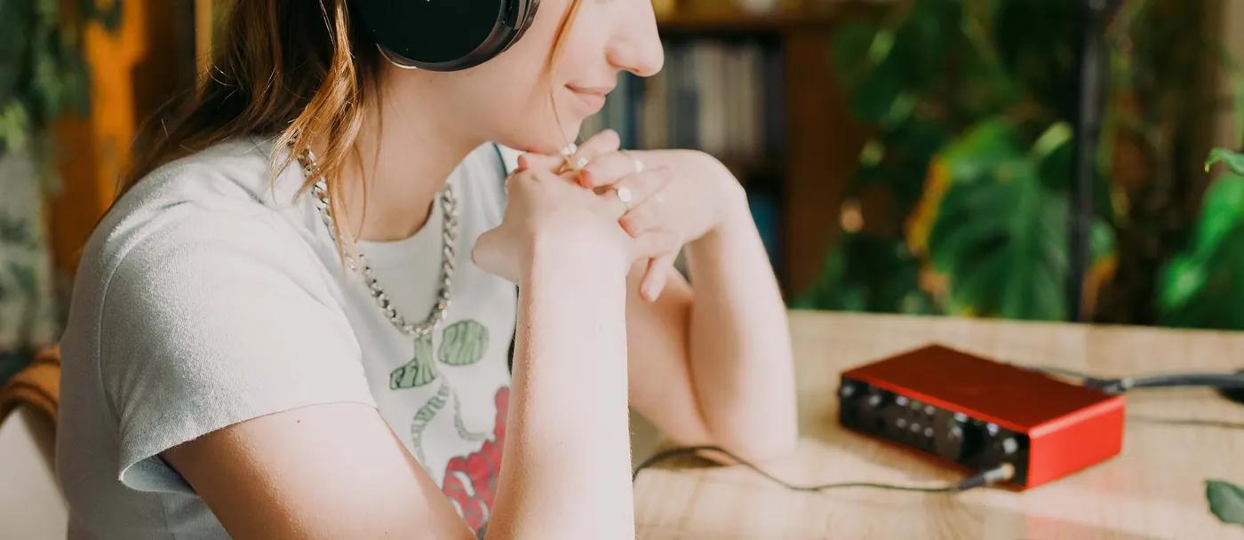 Personne portant le casque Scarlett SH-450, assise à une table devant une interface Scarlett Solo