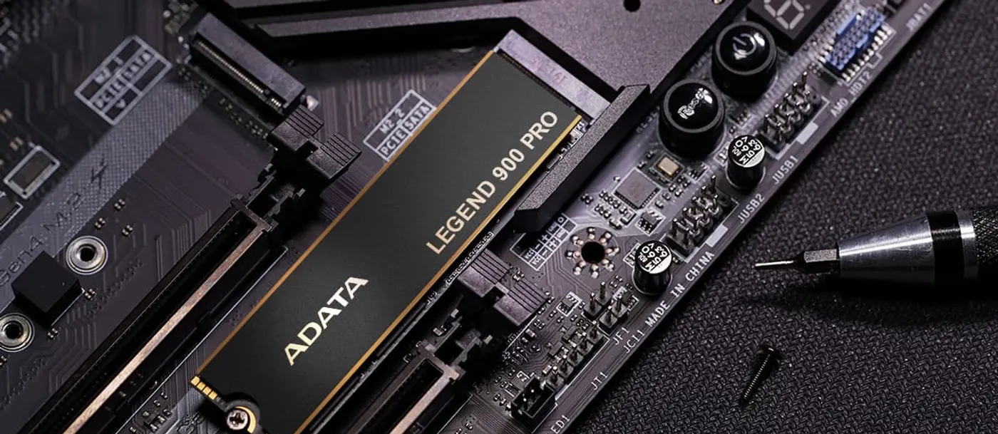 SSD ADATA LEGEND 900 PRO vissé dans un emplacement M.2 de carte mère, tournevis de précision à côté
